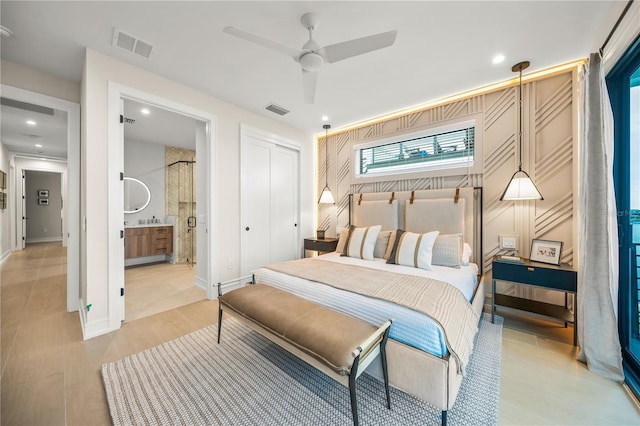 bedroom featuring ceiling fan, a closet, light wood-type flooring, and ensuite bath