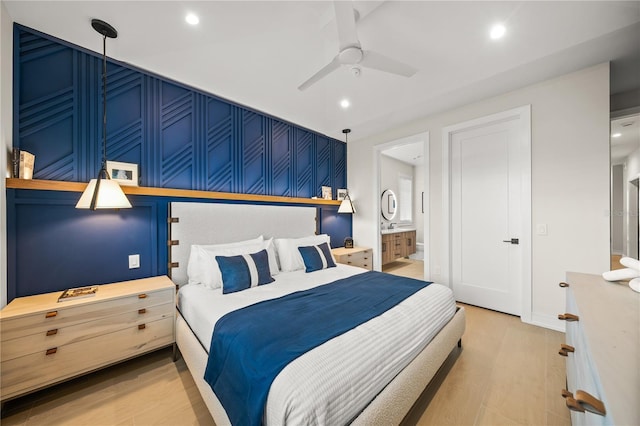 bedroom with hardwood / wood-style flooring, ceiling fan, and connected bathroom