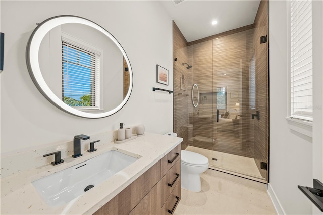 bathroom featuring tile patterned floors, vanity, toilet, and a shower with door