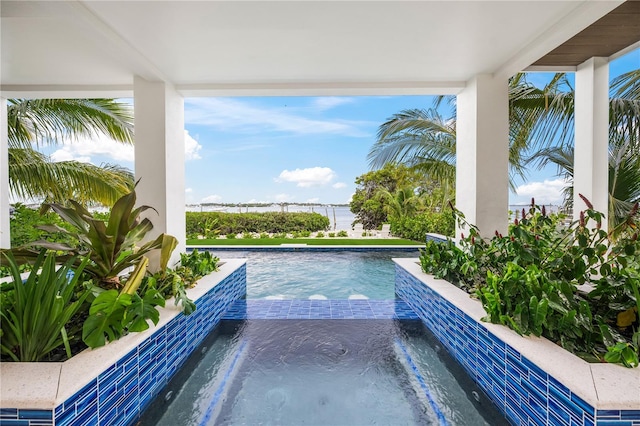 view of pool featuring an in ground hot tub and a water view