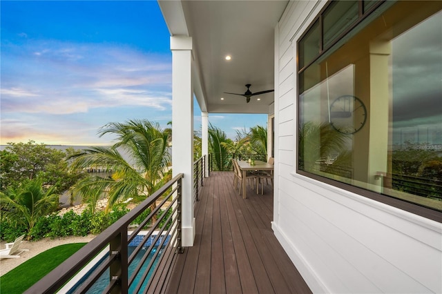 deck at dusk featuring ceiling fan