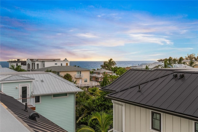 property exterior at dusk featuring a water view