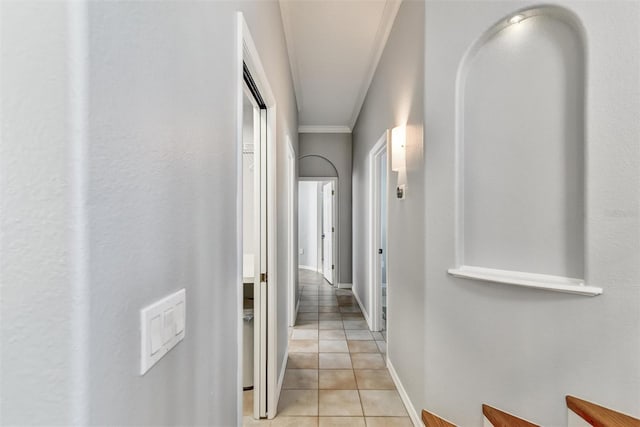 hallway featuring ornamental molding and light tile patterned floors