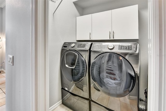 washroom featuring cabinets, washer and clothes dryer, and light tile patterned floors