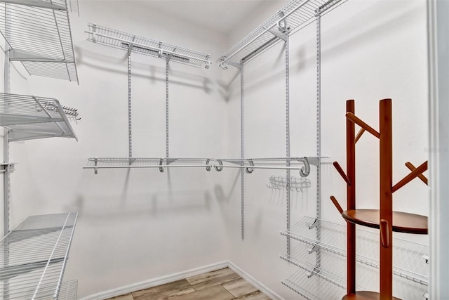 walk in closet with hardwood / wood-style floors