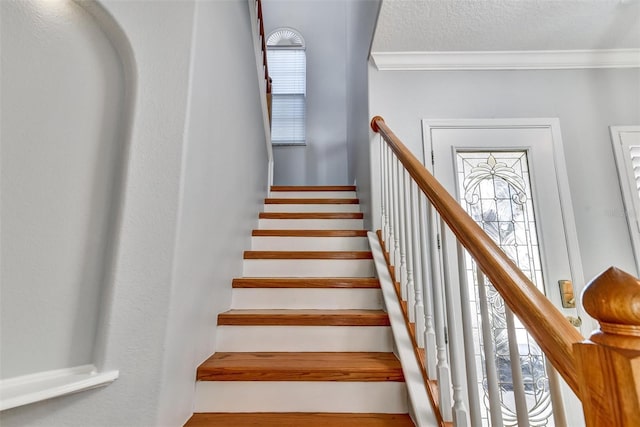 stairway featuring a wealth of natural light and ornamental molding