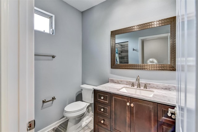 bathroom featuring vanity, hardwood / wood-style floors, and toilet