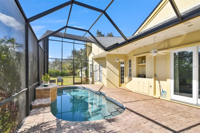 view of swimming pool featuring ceiling fan, a lanai, and a patio area