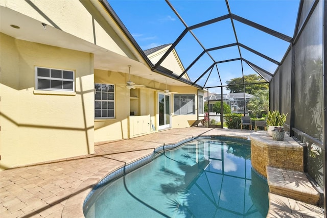 view of swimming pool with a patio, ceiling fan, and glass enclosure