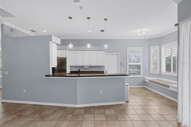 4708 Clipper Dr, Bradenton, FL 34208 - kitchen featuring a sink, stainless steel refrigerator, decorative light fixtures, white cabinetry, and dark countertops