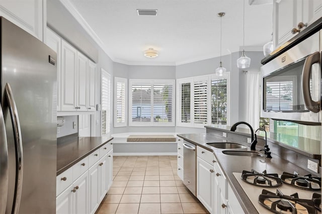 4708 Clipper Dr, Bradenton, FL 34208 - kitchen with white cabinets, dark countertops, stainless steel appliances, and a sink