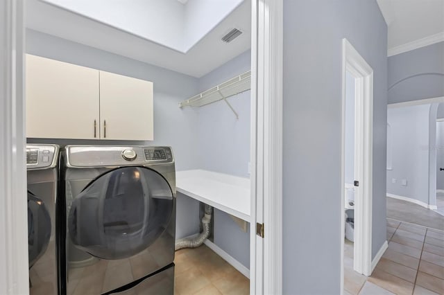 4708 Clipper Dr, Bradenton, FL 34208 - clothes washing area with light tile patterned floors, separate washer and dryer, visible vents, and cabinet space