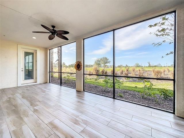 unfurnished sunroom with a wealth of natural light and ceiling fan