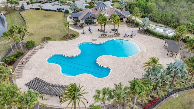 pool with a patio area and fence