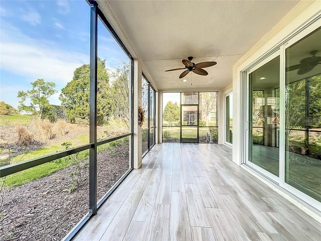 unfurnished sunroom with ceiling fan