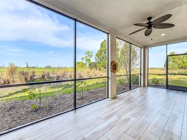 unfurnished sunroom featuring a ceiling fan