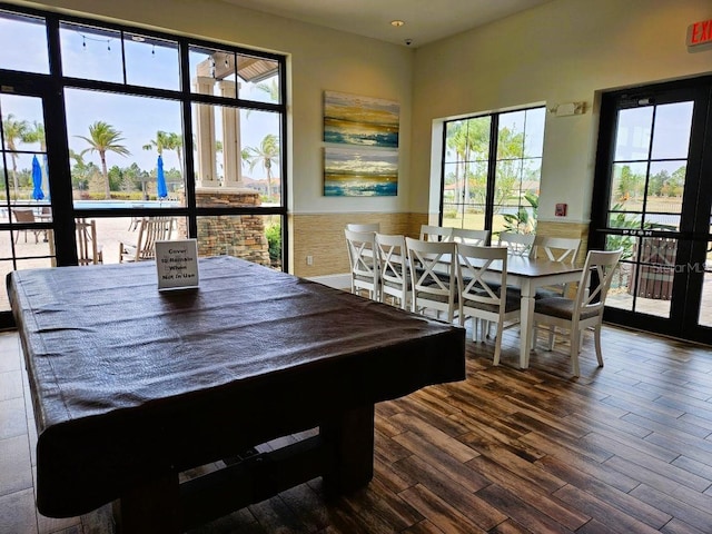 dining space featuring dark wood-style flooring and wainscoting