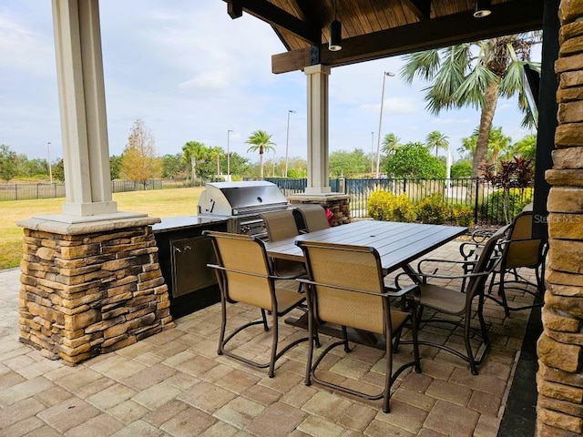 view of patio / terrace with outdoor dining area, area for grilling, fence, and a grill