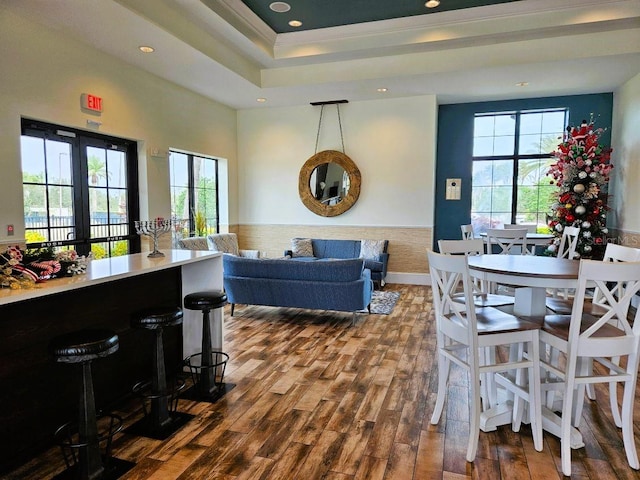 interior space featuring a raised ceiling, ornamental molding, dark wood-type flooring, french doors, and recessed lighting