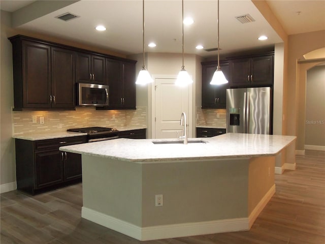 kitchen with stainless steel appliances, wood finished floors, a sink, and visible vents