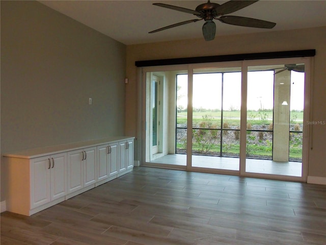 unfurnished room featuring baseboards, ceiling fan, and light wood finished floors