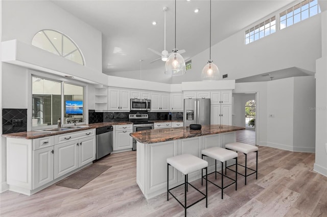 kitchen featuring white cabinetry, a center island, a breakfast bar, and appliances with stainless steel finishes