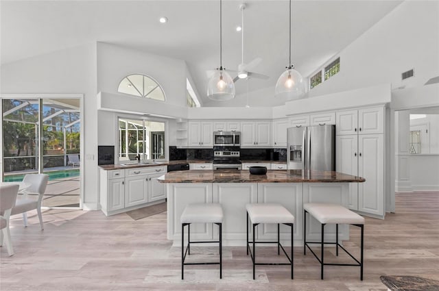 kitchen with stainless steel appliances, white cabinetry, and a kitchen island