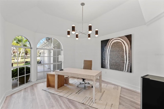 office with lofted ceiling, light hardwood / wood-style flooring, and a chandelier