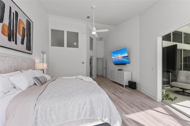 bedroom with ceiling fan, high vaulted ceiling, and light wood-type flooring