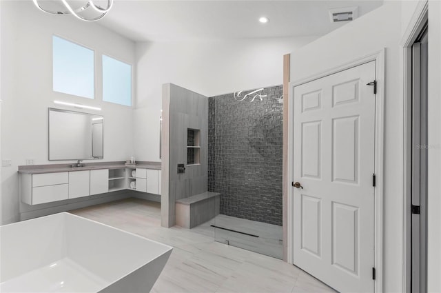 bathroom with vanity, independent shower and bath, and a high ceiling