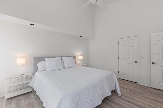 bedroom with a high ceiling and light wood-type flooring