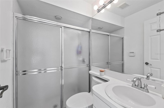 bathroom featuring toilet, vanity, and walk in shower