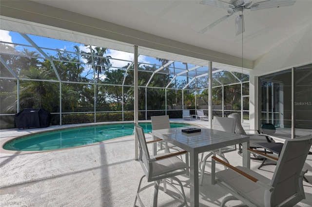 view of pool with a grill, a patio area, and glass enclosure