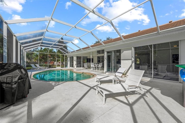 view of swimming pool featuring a lanai and a patio