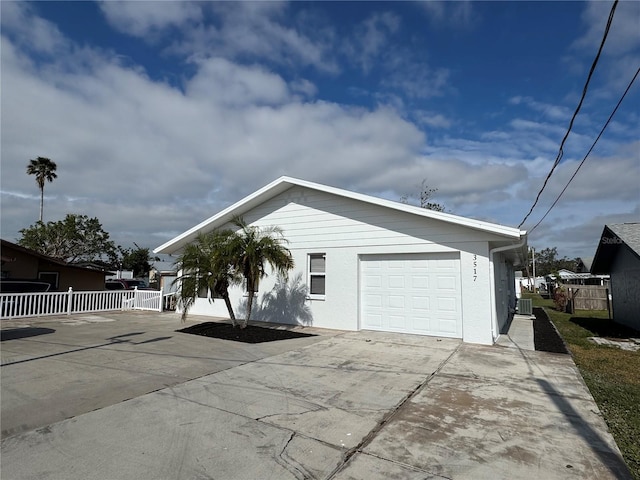 view of home's exterior with central AC and a garage