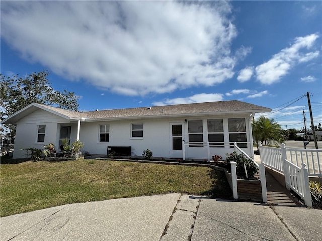 view of front facade featuring a sunroom and a front yard