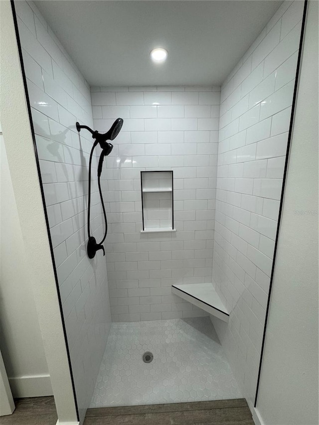 bathroom with hardwood / wood-style floors and tiled shower