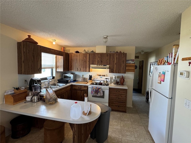 kitchen with a textured ceiling, kitchen peninsula, white appliances, and sink