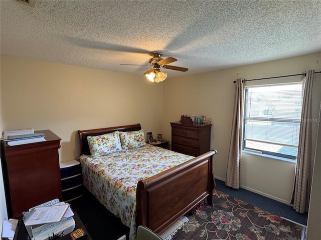 carpeted bedroom with ceiling fan and a textured ceiling