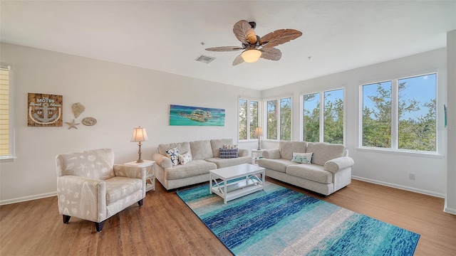 living room with a ceiling fan, baseboards, visible vents, and wood finished floors