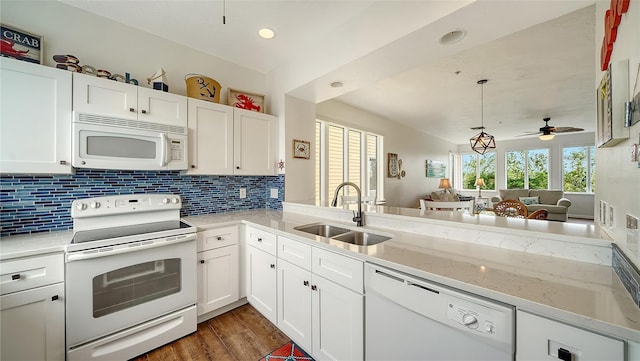 kitchen featuring white appliances, dark wood-style flooring, a sink, white cabinetry, and backsplash