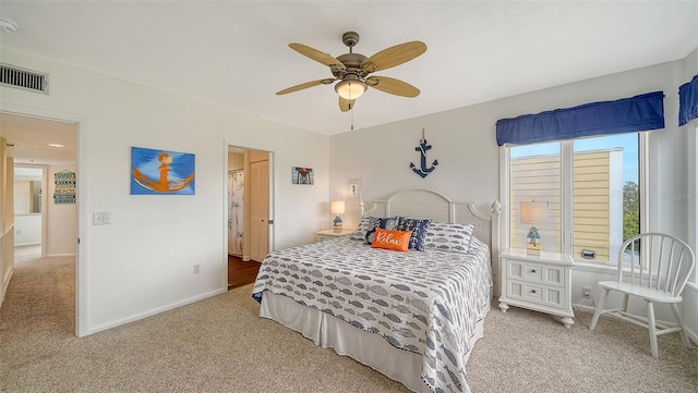 carpeted bedroom featuring a ceiling fan, visible vents, and baseboards