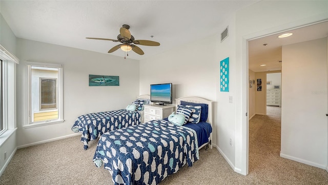 carpeted bedroom with visible vents, a ceiling fan, and baseboards