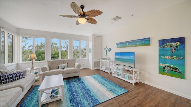 living room with ceiling fan, wood finished floors, visible vents, and baseboards