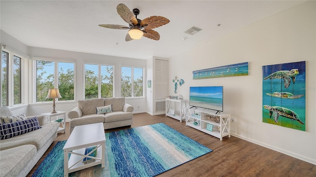 living room featuring visible vents, a ceiling fan, baseboards, and wood finished floors