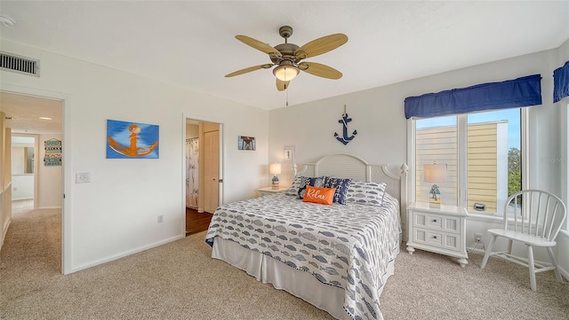 carpeted bedroom with baseboards, a ceiling fan, and visible vents