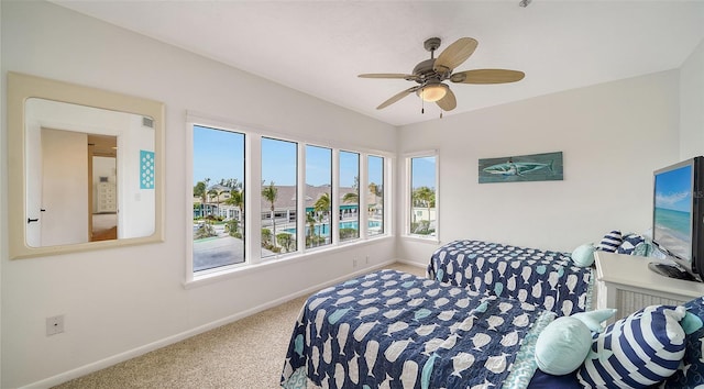 carpeted bedroom featuring baseboards and ceiling fan