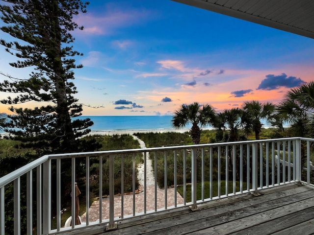 deck at dusk with a beach view and a water view