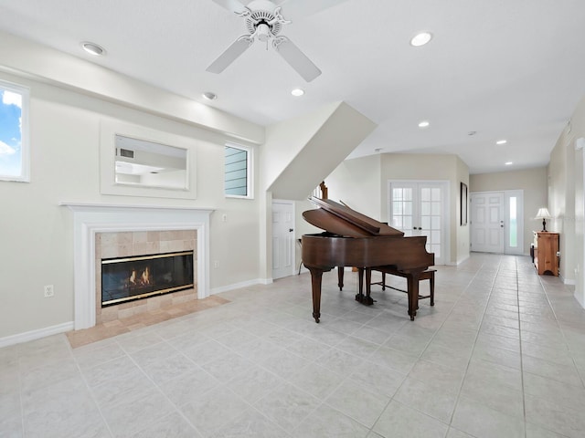 miscellaneous room with ceiling fan, light tile patterned floors, a fireplace, and a wealth of natural light