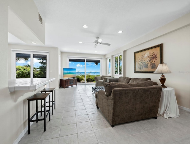 living room featuring ceiling fan, light tile patterned floors, and a healthy amount of sunlight